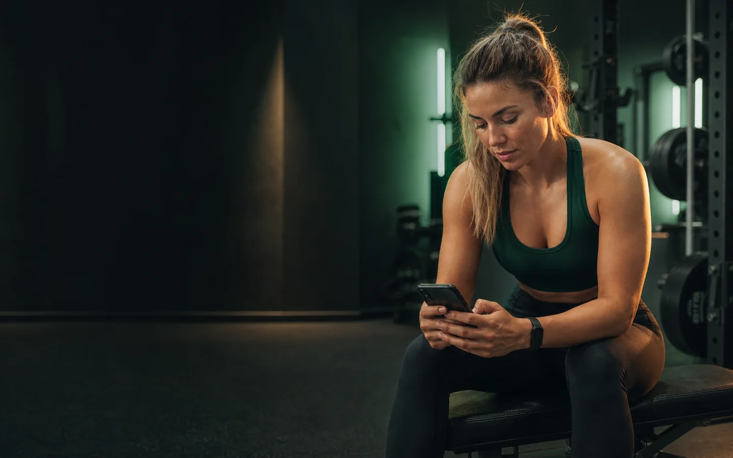 A client checking her training plan between strength sets